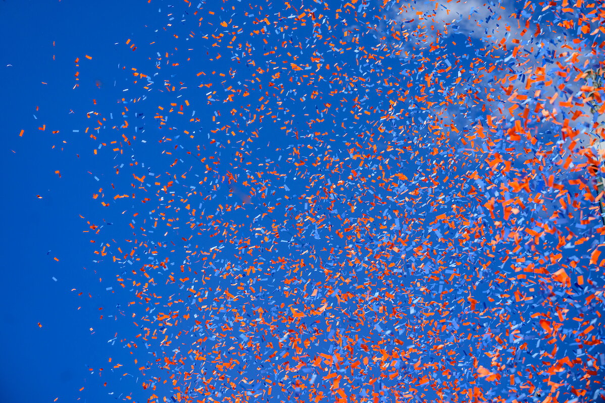 Orange and Blue confetti over a blue sky