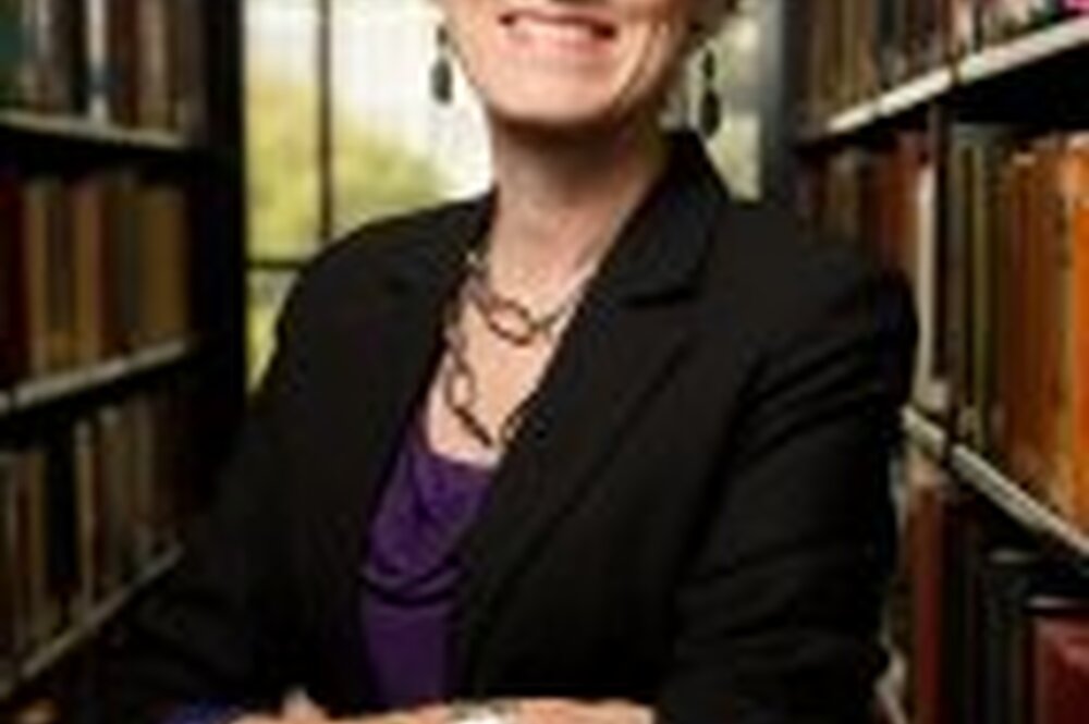 Professor Leslie Reagan, in front of stacks of books