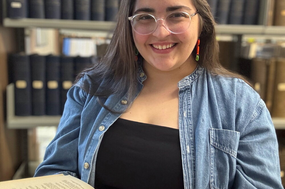 An image of Mary Schiavone holding a book.