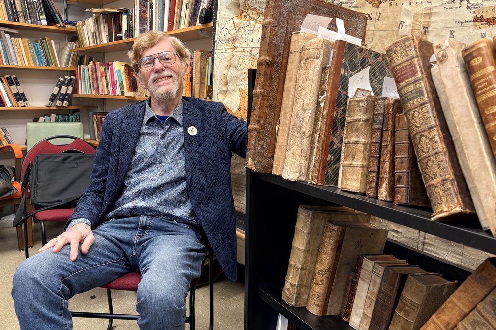 Ralph Mathisen poses with manuscripts from his own collection.