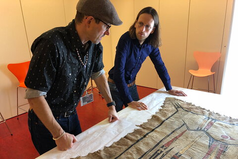 George Ironstrack, left, with Jonas Musco, a researcher at the Paris museum, examining one of the ceremonial robes.