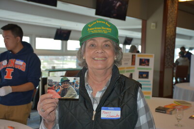 Woman holds up photograph at history harvest event