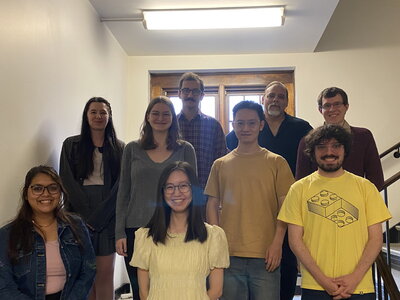 a group of students stands on the stairs in Gregory Hall