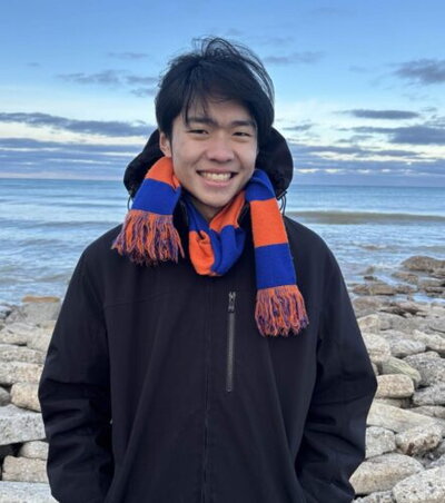 Lyndon Shi standing in front of a lake.