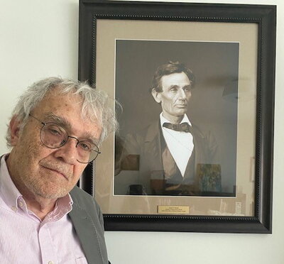 Jim Barrett poses with a photo of Abraham Lincoln