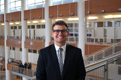 Noam Zipris standing in an atrium.
