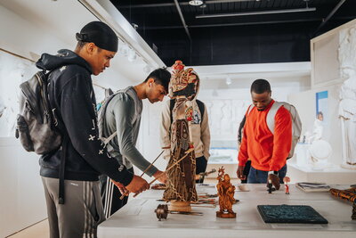 Students engage with historical objects in museum. 