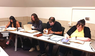 Students in Mathisen's manuscripts seminar examining their manuscripts.