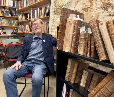 Ralph Mathisen poses with manuscripts from his own collection.