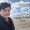 Richard Young posing in front of a prairie and mountain.