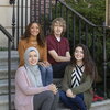 four students sitting on steps