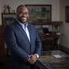 Nile Blunt standing in his office surrounded by paintings.