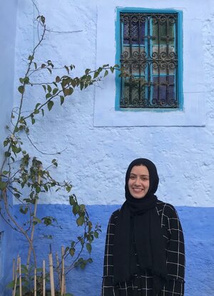 Yasmeen Ragab pictured outside, next to a tree and blue wall