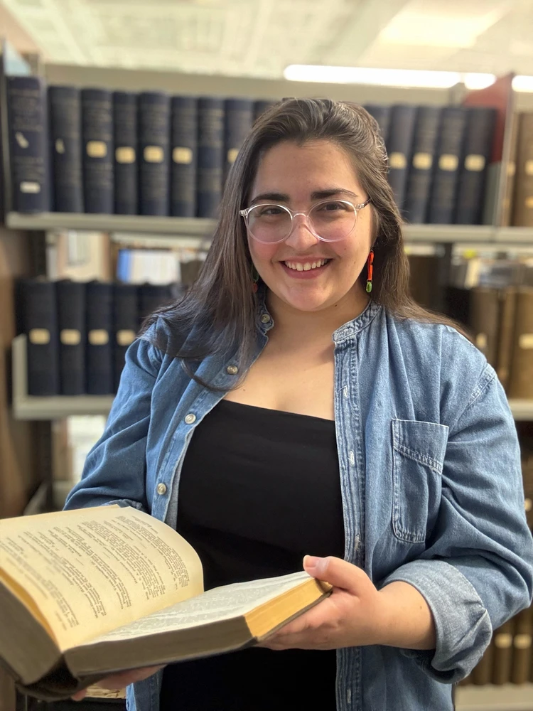 An image of Mary Schiavone holding a book.