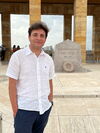 An image of Anthony in front of a memorial.