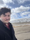 Richard Young posing in front of a prairie and mountain. 