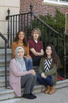 four students sitting on steps
