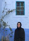 Yasmeen Ragab pictured outside, next to a tree and blue wall 