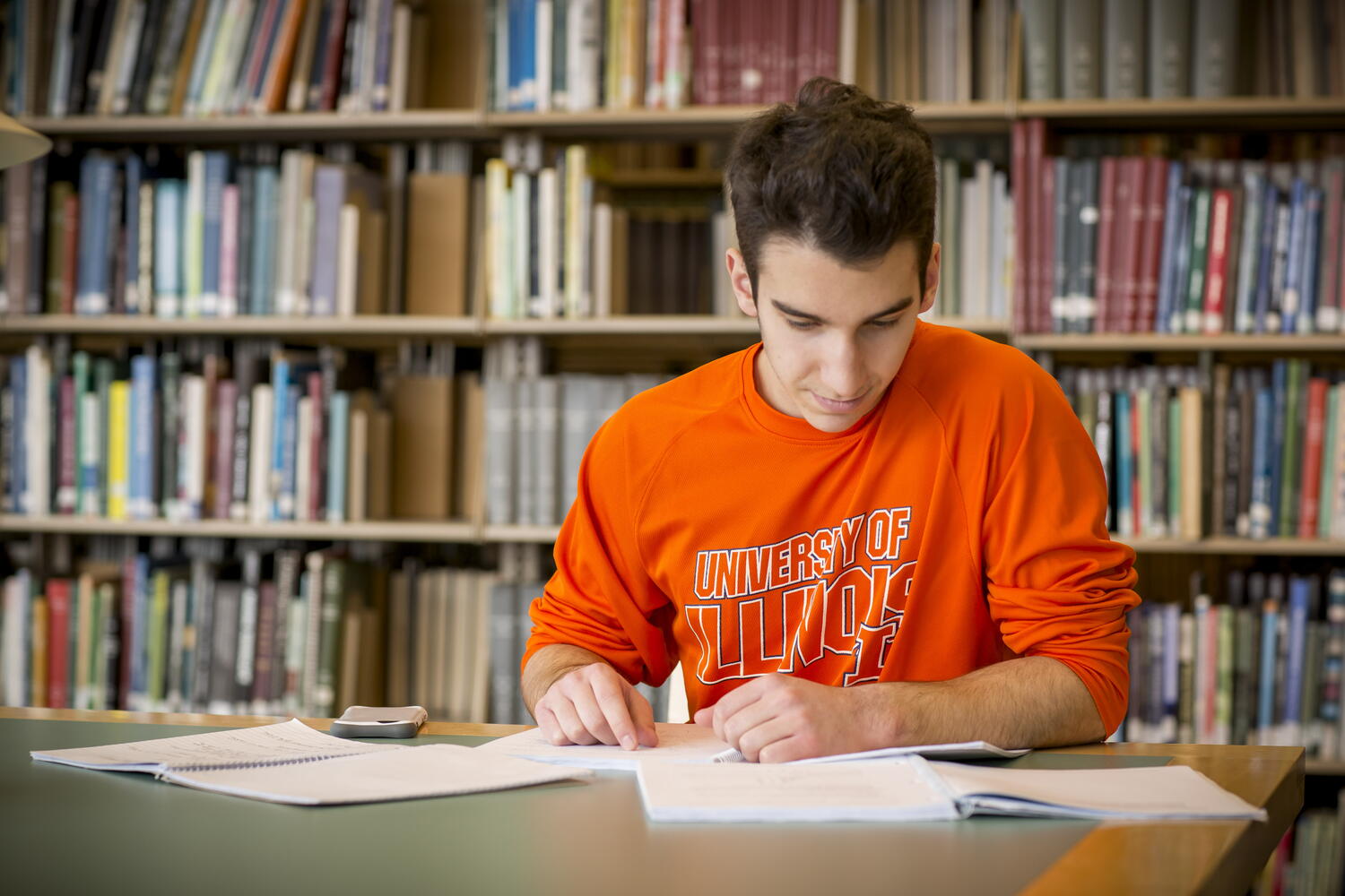 Student studying in front of bookshelf in Library