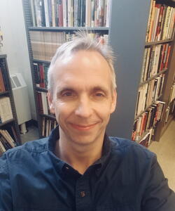 James Brennan near bookshelves.