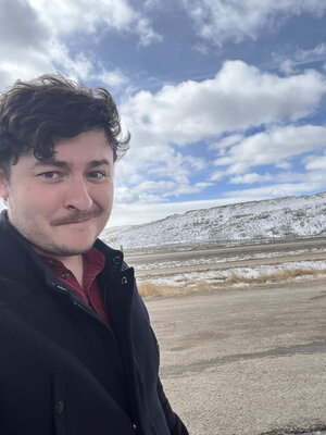 Richard Young posing in front of a prairie and mountain.