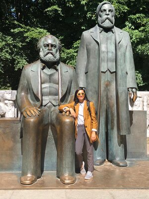 Amina Malik, next to a statue of Marx and Engels 