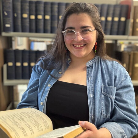 An image of Mary Schiavone holding a book.