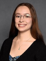 An image of Rachel smiling in front of a plain background.