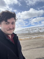Richard Young posing in front of a prairie and mountain.