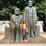 Amina Malik, next to a statue of Marx and Engels 